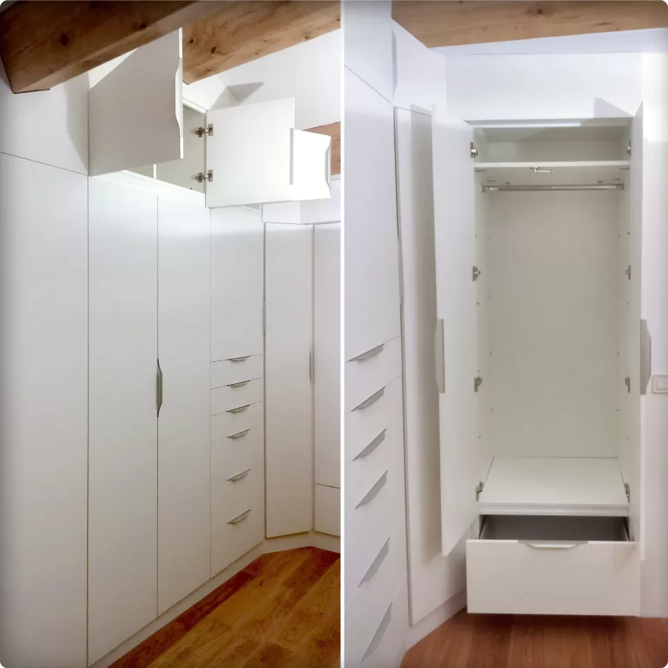 Dressing et rangements sur mesure occupant la totalité d'une paroi dans une pièce en soupente avec poutres apparentes.