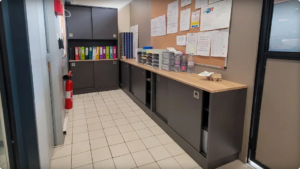 Meubles de rangement sur mesure haut et bas, avec portes coulissantes, dans l’ancienne zone de comptoir de la caisse centrale