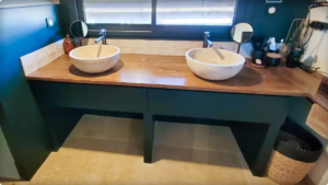 Tiroirs sous vasque sur mesure ajoutés sous un plan existant, intégrés au bâti de la salle de bain des parents.